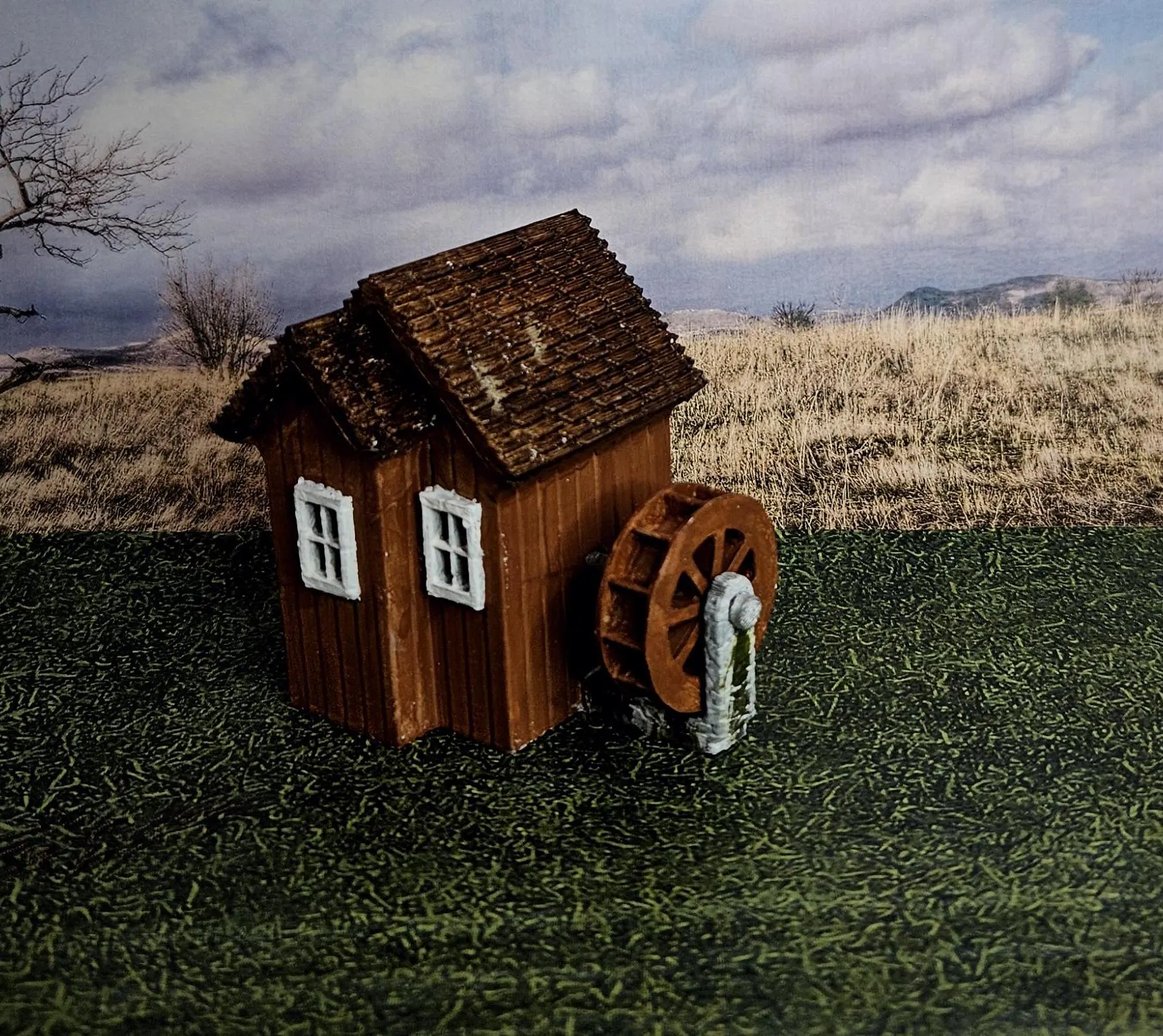 Angled view of HO scale waterwheel with medium building